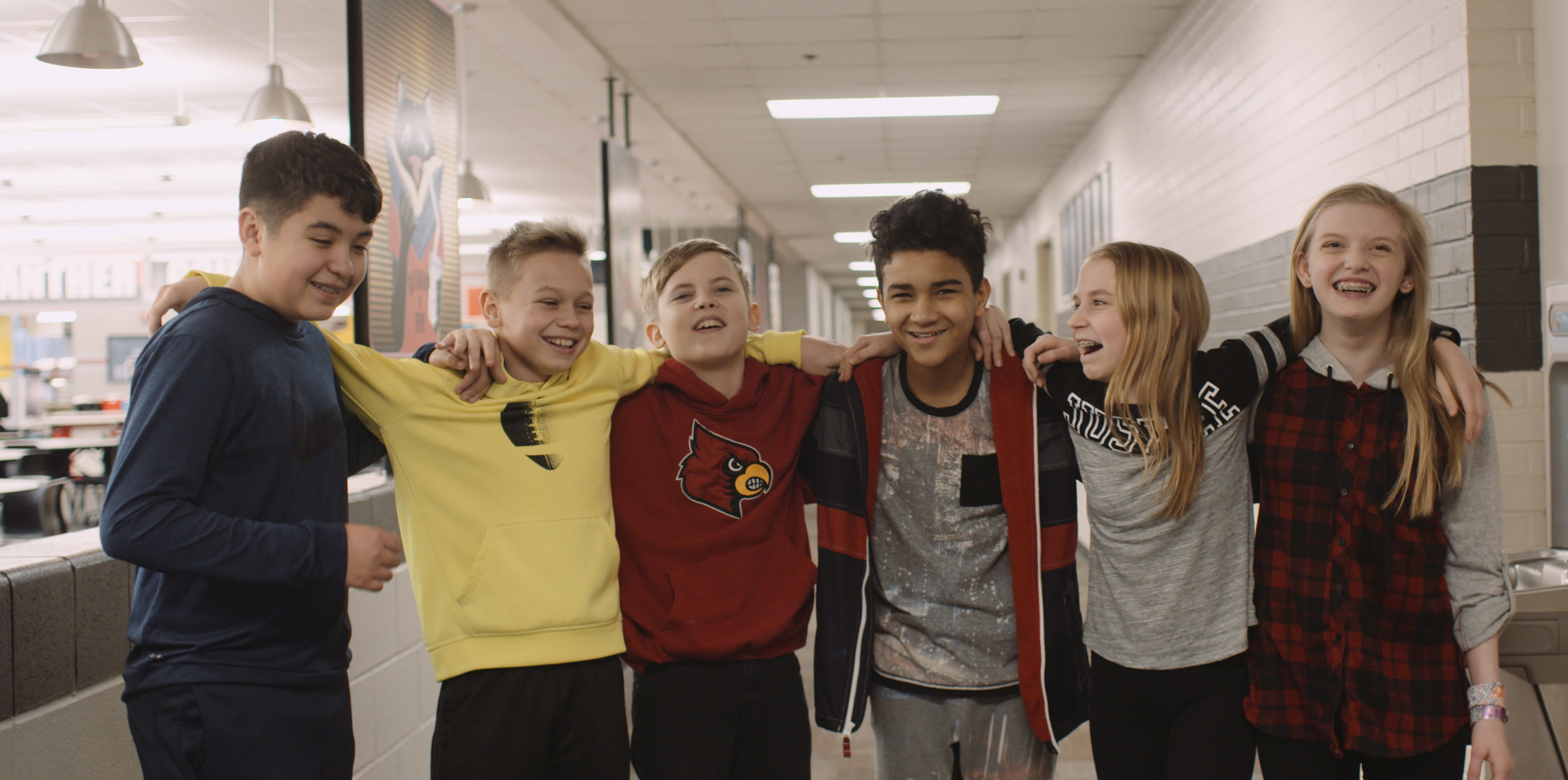 Middle school boys and girls interlocking arms and laughing