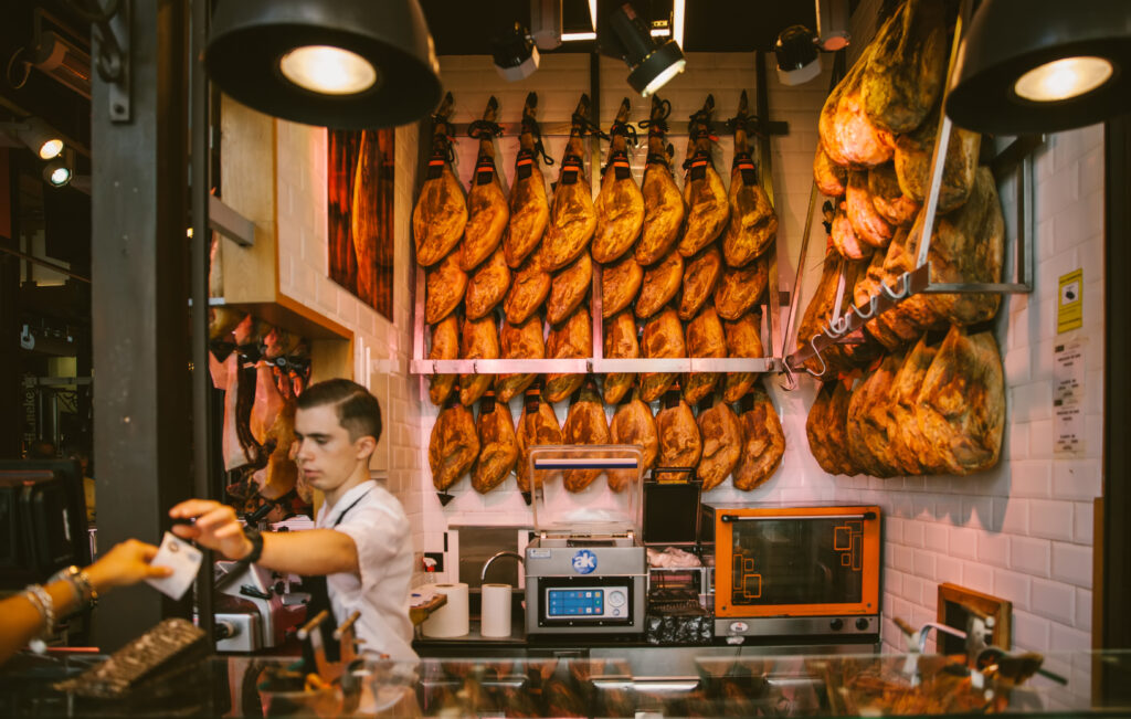 Madrid, Spain - September 7th, 2017: Customers buying ham at San Miguel Market in Madrid,Spain. According to Tripadvisor, it is the 2nd top shopping destination in Madrid.