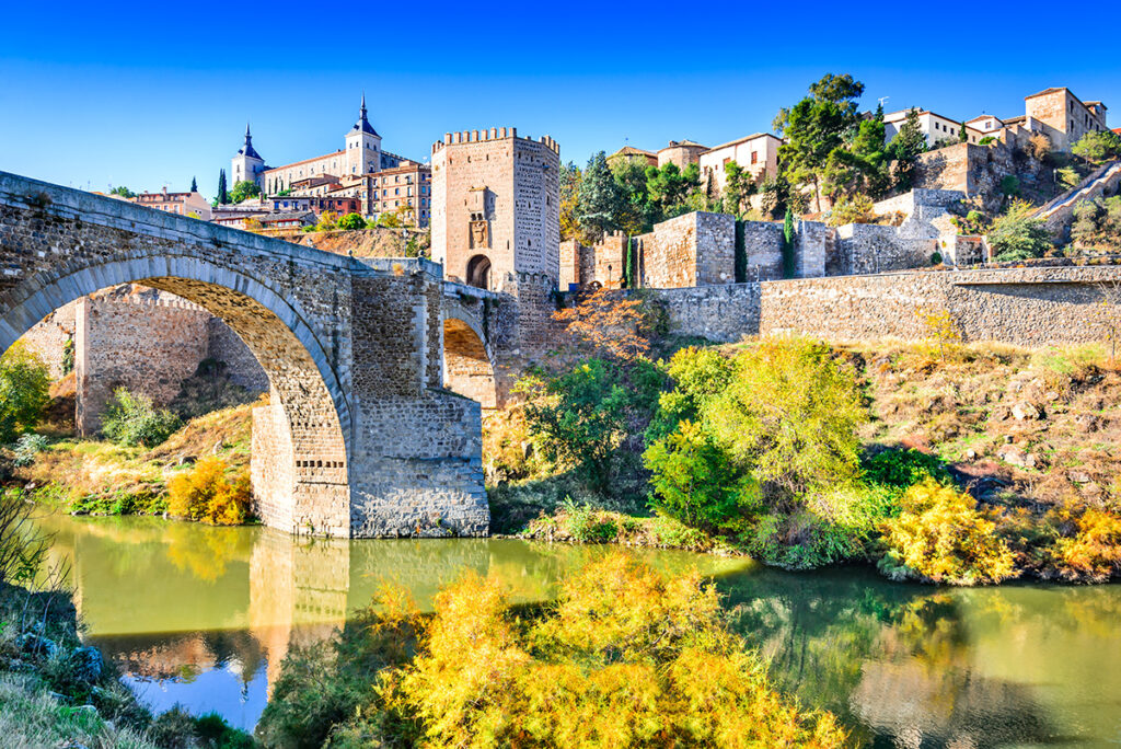 Toledo, Spain. Alcazar and Alcantara Bridge ( Puente de Alcantara), an arch bridge in Toledo, spanning the Tagus River.